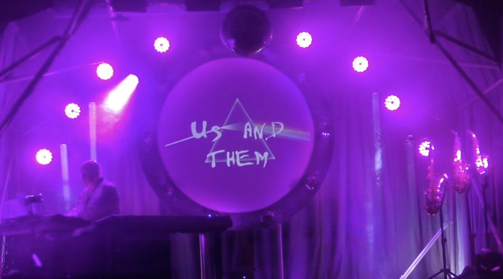Us and Them — title card on the circular projection screen